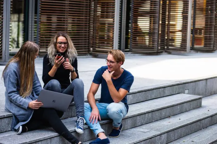 pexels-buro-millennial-636760-1438072 3 younger looking people sitting on steps with laptops