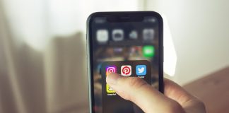 person holding mobile phone with social media open