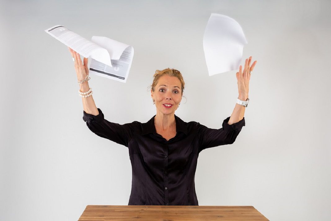 stressed woman throwing papers in the air