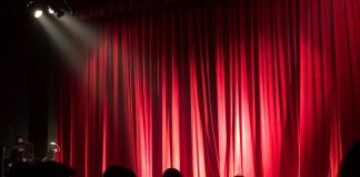 spotlight on empty stage with red curtain