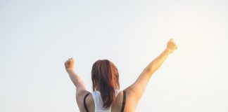 woman raising hands in triumph