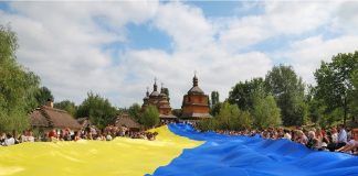 gropu of people holding huge Ukrainian flag