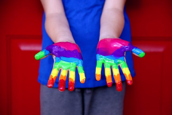 person with rainbow paint on hands