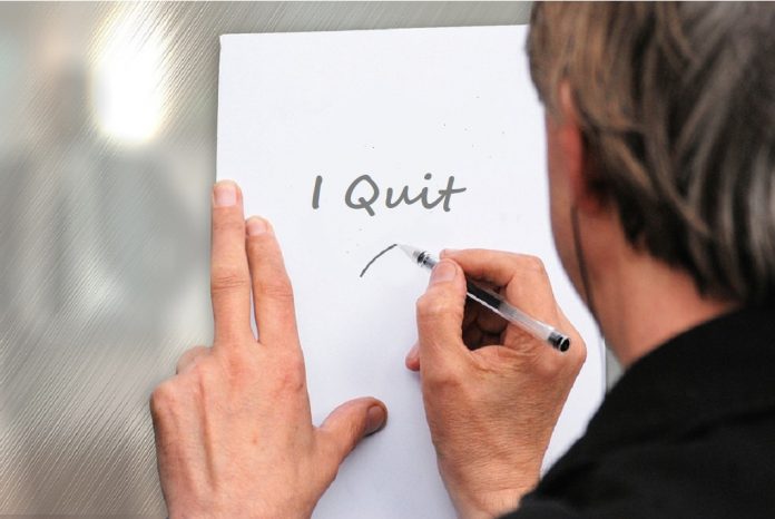 man writing note on paper