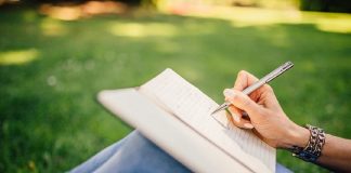 woman sittting in garden writing notes