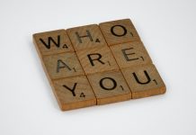 wooden scrabble tiles spelling out "who are you" in a square 3x3