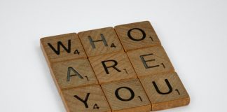 wooden scrabble tiles spelling out "who are you" in a square 3x3