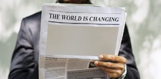 newspaper with headline reading the world is changing