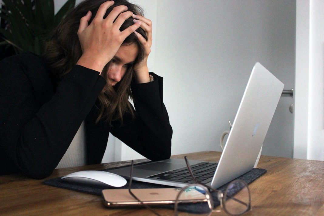distressed woman sitting at laptop