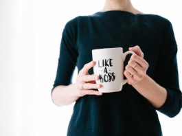 lady in black clothes holding a mug that says "like a boss"
